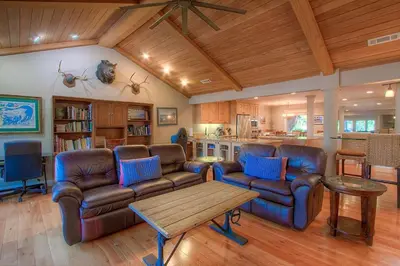 a living room with couches and a table and a kitchen at Chipmunk's Paradise condo in Kings Beach