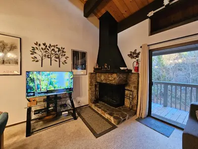 a living room with a television and a fireplace at Forest View Townhouse home in Kings Beach