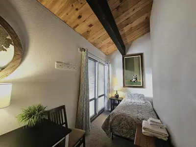 a bedroom with a bed and a table and a window at Forest View Townhouse home in Kings Beach
