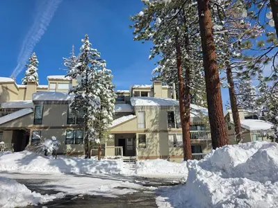 a building covered in snow with trees and snow piled up at Forest View Townhouse home in Kings Beach