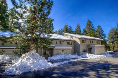 a house with snow piled up in front of it at Eagle's Lake Retreat condo in Incline Village