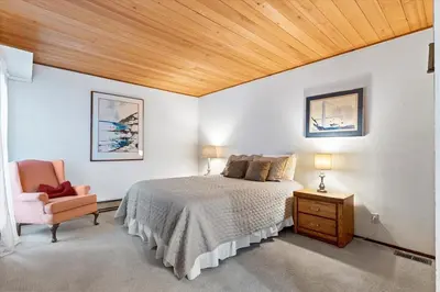 a bedroom with a bed and a chair at Raccoon Roost condo in Incline Village