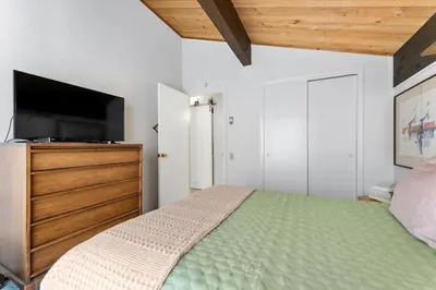 a bedroom with a bed and a flat screen tv at Raccoon Roost condo in Incline Village