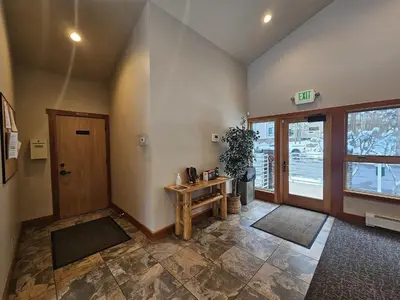 a room with a hallway with a table and a door at Raccoon Roost condo in Incline Village