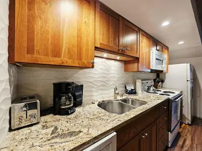 a kitchen with wooden cabinets and a sink and a refrigerator at Cartwright Corner Condo townhouse in Incline Village