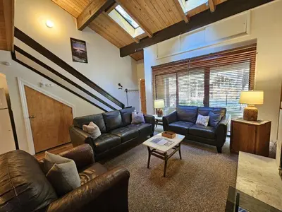 a living room with leather couches and a table at Cartwright Corner Condo townhouse in Incline Village