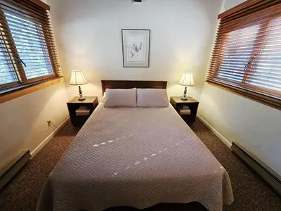 a bedroom with a large bed with two lamps at Cartwright Corner Condo townhouse in Incline Village
