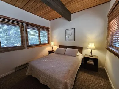 a bedroom with a bed with two night stands and two windows at Cartwright Corner Condo townhouse in Incline Village