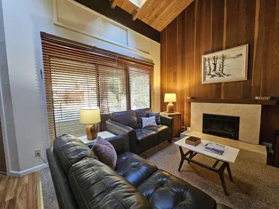 a living room with a leather couch and a fireplace at Cartwright Corner Condo townhouse in Incline Village