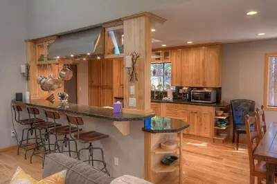 a kitchen with wooden cabinets and a counter with bar stools at Gale Force Wind home in Incline Village