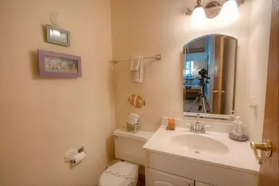 a bathroom with a sink and a toilet and a mirror at Whispering Wood home in Incline Village