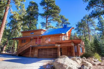 a large wooden house with a balcony and a garage at The Bass Chalet home in Kings Beach