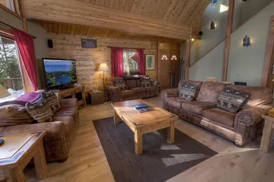 a living room with couches and a tv in a cabin at The Bass Chalet home in Kings Beach