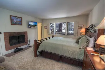a bedroom with a bed and a fireplace at Blue Laulea home in Incline Village