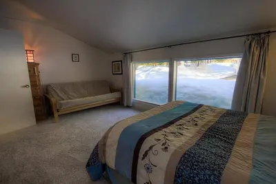 a bedroom with a bed and a large window at Blue Laulea home in Incline Village