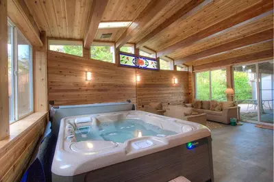 a large jacuzzi tub in a room with wooden walls at Cheyenne Chalet home in Round Hill