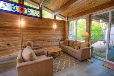 a living room with two couches and a stained glass window at Cheyenne Chalet home in Round Hill