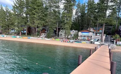 a dock with a beach with houses and a shoreline at Zephyr Cabin home in Zephyr Cove