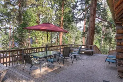 a patio with a table and chairs and an umbrella at Zephyr Cabin home in Zephyr Cove