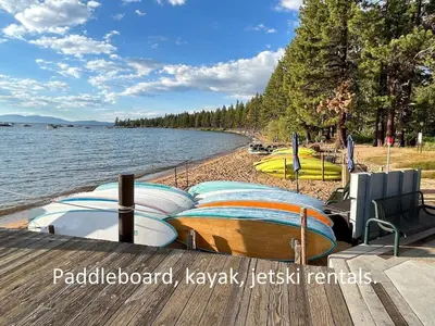 a row of boats on a dock next to a lake at Zephyr Cabin home in Zephyr Cove
