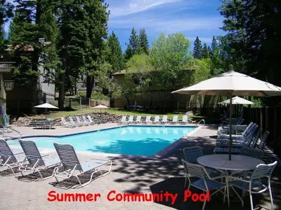 a pool with chairs and a table and an umbrella at Kingswood Cornerview home in Kings Beach