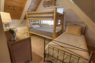 a attic room with two bunk beds and a window at Cozy Mountain Hideaway home in Incline Village