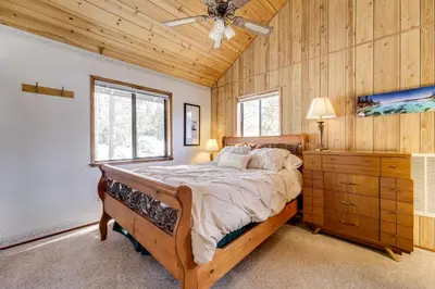 a bedroom with a bed and a wooden wall at 6 Mi to Sugar Bowl Resort Soda Springs Cabin! in Soda Springs