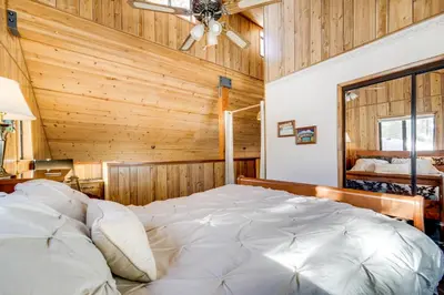 a bedroom with a large bed in a room with wooden walls at 6 Mi to Sugar Bowl Resort Soda Springs Cabin! in Soda Springs