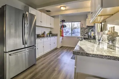 a kitchen with a stainless steel refrigerator and white cabinets at Gateway to Mt Rose Ski! Reno Home with Fireplace in Reno