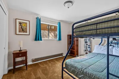 a bedroom with a bunk bed and a table and a window at Big Trees, Little Cabin in Arnold