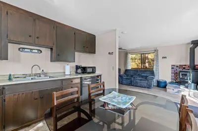 a kitchen with a sink and a table in a room at Big Trees, Little Cabin in Arnold