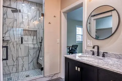 a bathroom with a shower and a sink and a mirror at 4BR Victorian Walk to UC Davis & Shriner Med Cen in Sacramento