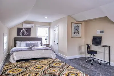 a bedroom with a large bed and a chair at 4BR Victorian Walk to UC Davis & Shriner Med Cen in Sacramento