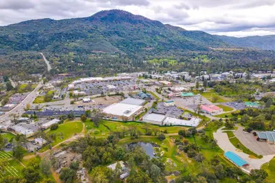 an aerial view of a park with mountains in the background at Dog-Friendly Oakhurst Home Walk to Downtown! in Oakhurst