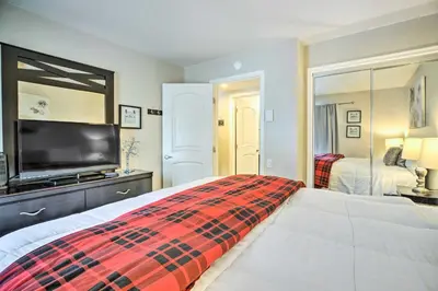 a bedroom with a bed and a flat screen tv at Mammoth Lakes Condo with Pool and Spa Access! in Mammoth Lakes