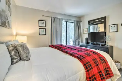 a bedroom with a white bed with a plaid blanket on it at Mammoth Lakes Condo with Pool and Spa Access! in Mammoth Lakes