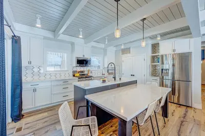 a kitchen with white cabinets and a large island at The Home at the End of the Rainbow in South Lake Tahoe