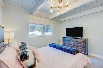 a bedroom with a bed and a flat screen tv at The Home at the End of the Rainbow in South Lake Tahoe