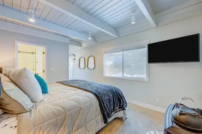 a bedroom with a bed and a flat screen tv at The Home at the End of the Rainbow in South Lake Tahoe