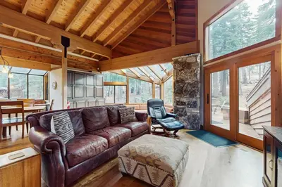 a living room with a leather couch and a chair at North Star Mountain Retreat in Truckee