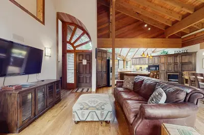 a living room with a leather couch and a large television at North Star Mountain Retreat in Truckee