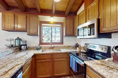 a kitchen with wooden cabinets and a sink and a window at Tree-Lined Views #8 in Tahoe City