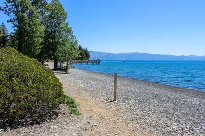 a rocky beach with trees and a body of water at Tree-Lined Views #8 in Tahoe City