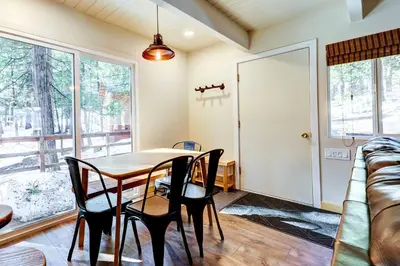 a dining room with a table and chairs and a couch at Hike, Fish and Explore California Cabin with Deck! in Long Barn
