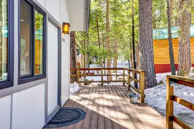 a wooden deck with a bench next to a house at Hike, Fish and Explore California Cabin with Deck! in Long Barn