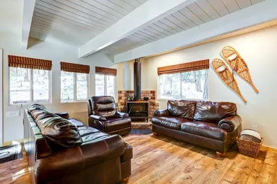 a living room with leather furniture and a fireplace at Hike, Fish and Explore California Cabin with Deck! in Long Barn