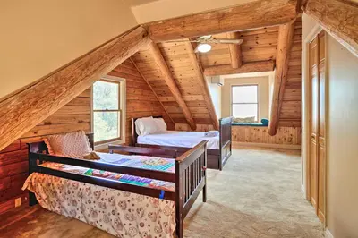 a bedroom with two beds in a log cabin at Stunning Log Cabin with Great Views, Firepit, Deck near Twain Hart in Sonora