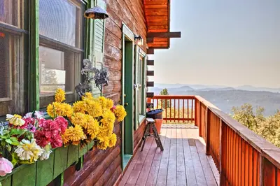 a balcony with flowers on the side of a house at Stunning Log Cabin with Great Views, Firepit, Deck near Twain Hart in Sonora