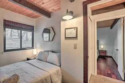 a bedroom with a bed and a window and a mirror at Peaceful Oak Haven Cabin near Yosemite in Mariposa