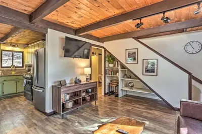 a kitchen and living room with wooden ceilings and a staircase at Peaceful Oak Haven Cabin near Yosemite in Mariposa